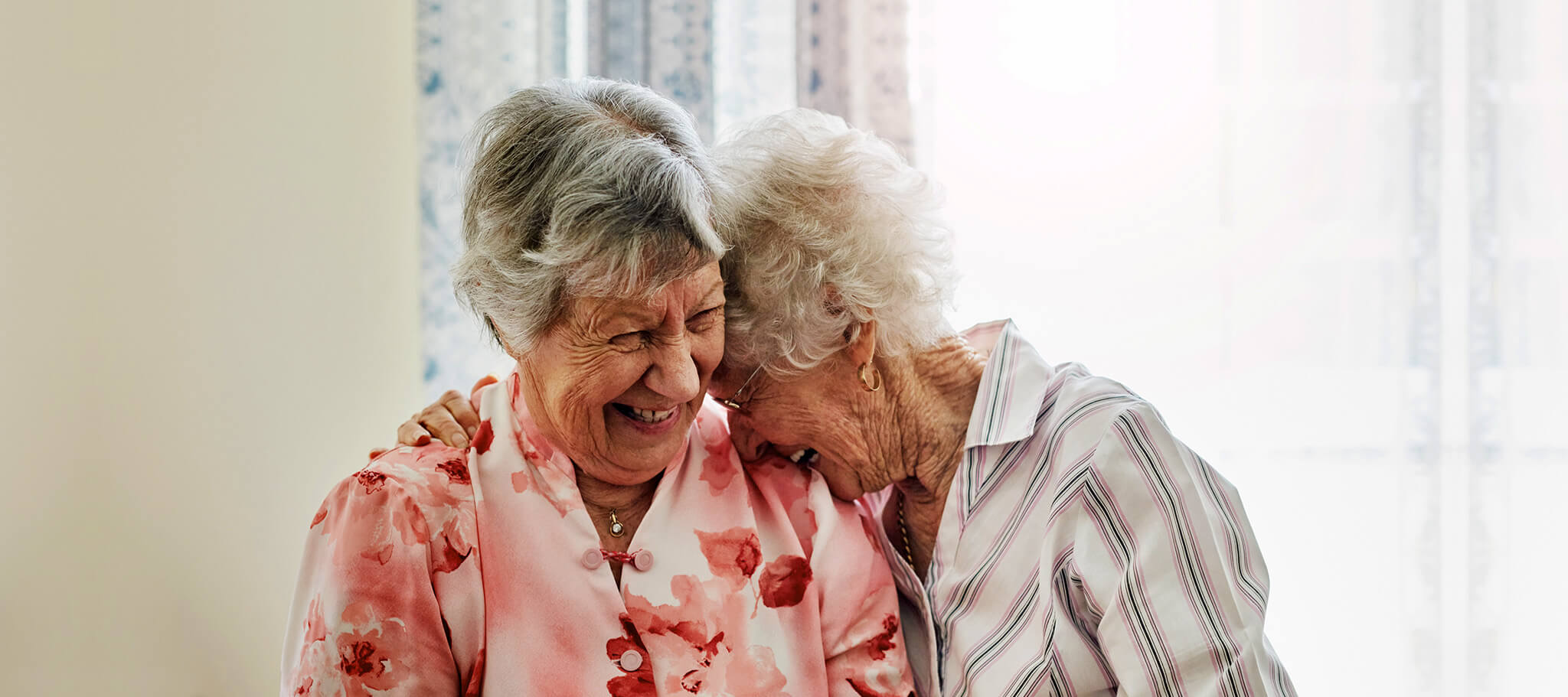 Ältere Menschen - Aufnahme von zwei glücklichen älteren Frauen, die zu Hause Zeit miteinander verbringen.