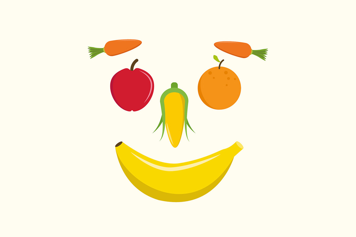 Lächelndes Gesicht aus Gemüse und Obst gemalt