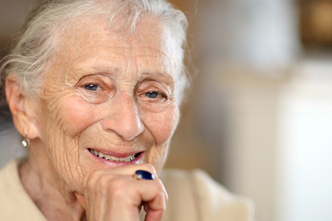 Gesund Altern und Pflegen im Quartier: ältere Frau lächelt in Kamera