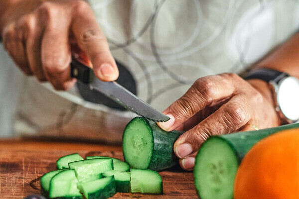 Person schneidet eiine Gurke